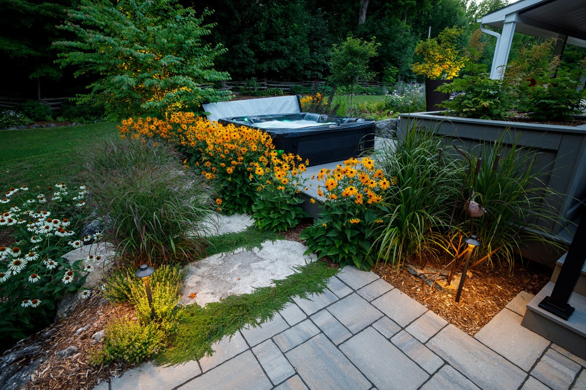 Native garden and hot tub in a backyard.